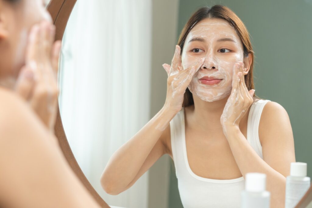 Person applying cleanser to their face.